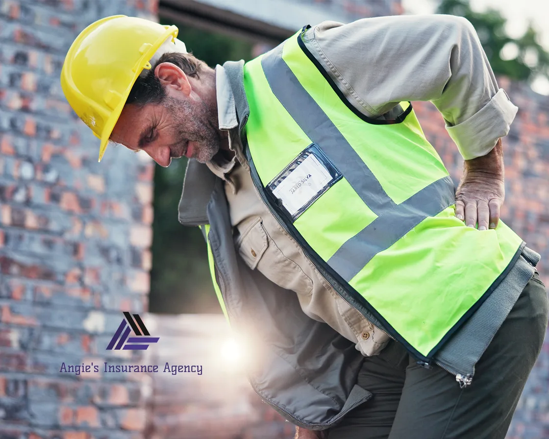 Construction worker in a hard hat and hi-vis vest holding his back after an on-the-job injury